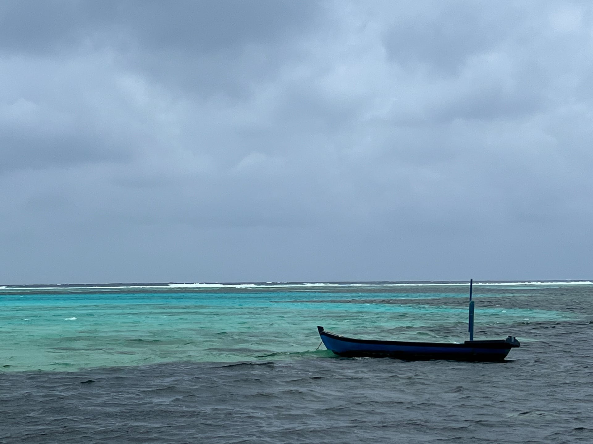 Lone boat on a turquoise lagoon